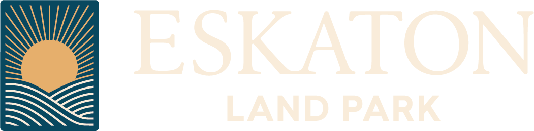 Logo for Eskaton Land Park featuring a stylized sun rising over waves on the left, with the text ESKATON LAND PARK in large, light-colored letters to the right.