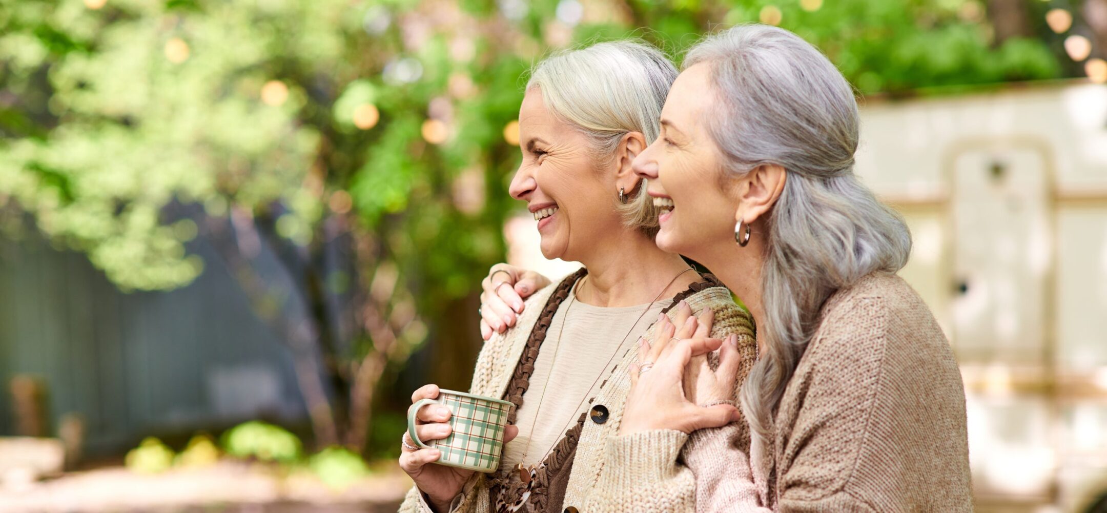 Two senior women embracing each other. Pride Coffee & Convo