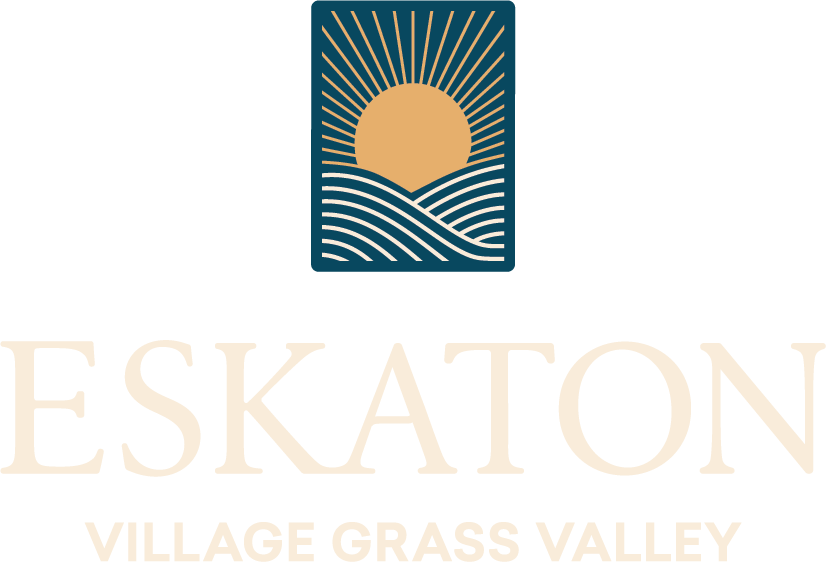 Eskaton Village Grass Valley logo featuring a stylized sun rising over waves, with bold rays extending upward, above the text ESKATON VILLAGE GRASS VALLEY in large, light-colored letters.