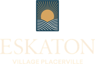 Logo with a stylized sun rising over curved lines representing hills or waves, above the text ESKATON Village Placerville in light-colored, elegant font.