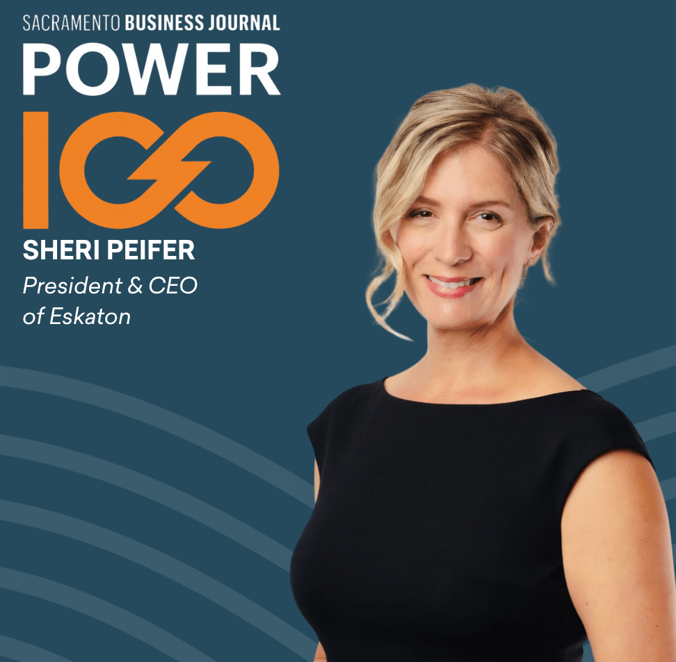 Sheri Peifer, President & CEO of Eskaton, smiles in a black dress. Text reads “Sacramento Business Journal Power 100” beside her, with a blue background and orange wave design.