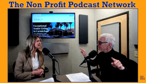 Two people sit at a podcast table with microphones, talking and smiling. A screen behind them displays Exceptional Senior Living in Carmichael. The text above reads The Non Profit Podcast Network.