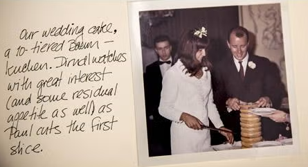 A bride and groom cut a tall, layered wedding cake together while guests watch. Handwritten text describes the scene and mentions the cake is a 10-tiered Baumkuchen—a sweet centerpiece that feels like coming home for everyone gathered to celebrate.